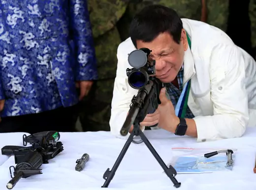 Philippine President Rodrigo Duterte checks the scope of a 7.62mm sniper rifle during the turnover ceremony of China's urgent military assistance given "gratis" to the Philippines, at Clark Air Base, near Angeles City, Philippines, on June 28, 2017. 