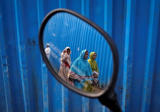 Dawoodi Bohra women walk past a construction site. 