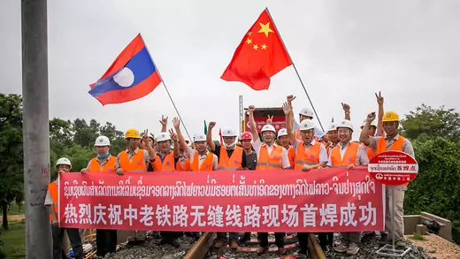 Workers from China Railway No.2 Engineering Group pose for a group photo after welding the first seamless rails for the China-Laos railway in the northern suburb of Vientiane, Laos, on June 18, 2020. 