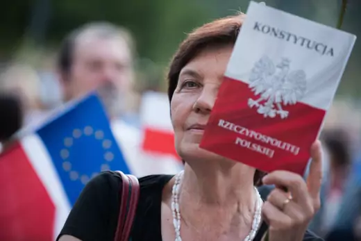 A woman holds a Polish Constitution during a protest in favour of European Commission move urging EU leaders to press forward with disciplinary action against Poland for allegedly violating rule-of-law standards in front of the Courts in Krakow.