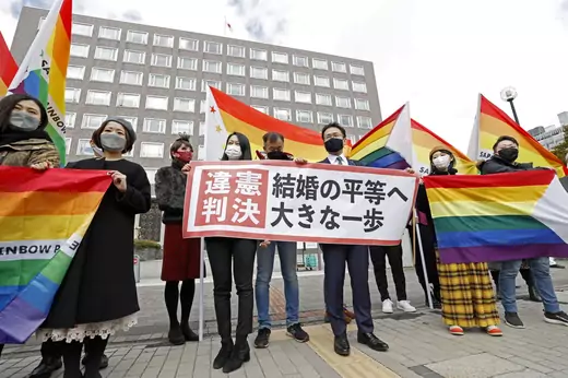 Plaintiffs' lawyers and supporters show a banner stating the ruling found the government measures unconstitutional, after a district court ruled on the legality of same-sex marriages outside Sapporo District Court
