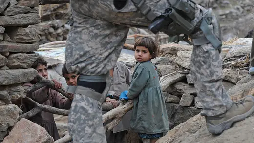A U.S. soldier walks past playing children in the mountains of Afghanistan.