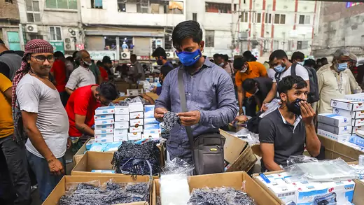 A shopper peruses masks at a street market in Dhaka, Bangladesh.
