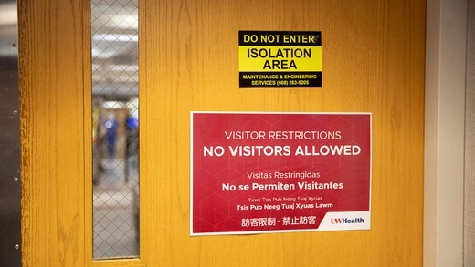 Signage hangs on entry doors to a hospital wing housing coronavirus disease (COVID-19) patients at UW Health University Hospital in Madison, Wisconsin.