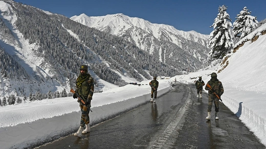 Indian army soldiers walk along a road near Zojila mountain pass that connects Srinagar to the union territory of Ladakh, bordering China, on February 28, 2021.