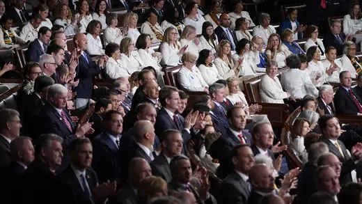 Female members of Congress wearing white, hold up three fingers for the HR3 health care bill as U.S. President Donald Trump talks about health care during his State of the Union address to a joint session of the U.S. Congress in the House Chamber of the U.S. Capitol in Washington, U.S.