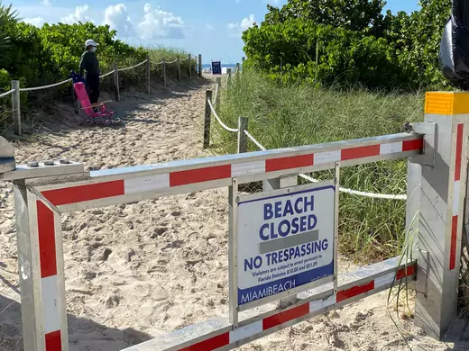 A sign informing about South Beach closure, to prevent the spread of the coronavirus disease (COVID-19), is seen ahead of the Fourth of July weekend, in Miami Beach, Florida, U.S., July 3, 2020.  REUTERS/Elizabeth Feria   REFILE - CORRECTING LOCATION - RC2SLH94WEHT