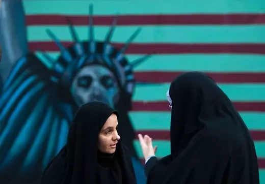 Iranian women stand in front of an anti-U.S. mural painted on the wall of the former U.S. Embassy in Tehran November 4, 2011.