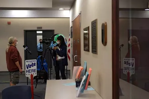 A reporter interviews a voter at the city clerk’s office as early voting for the upcoming presidential election begins in Appleton, Wisconsin, U.S., October 20, 2020.  REUTERS/Gabriela Bhaskar - RC2JMJ91T20D