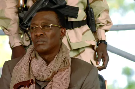 A picture of recently deceased Chadian President Idriss Deby, sitting in front of a soldier wearing military fatigues.