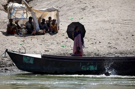 People fleeing Tigray stand on the riverbank between Sudan and Ethiopia. 