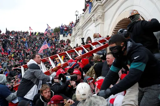Pro-Trump protesters, holding a ladder, storm the U.S. Capitol on January 6, 2021.