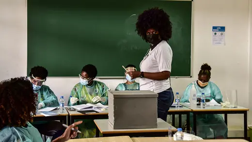 A citizen wearing a face mask looks back after casting her ballot in a university classroom during parliamentary elections in April 2021 in Praia, Cape Verde.