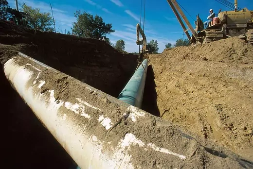 A 42-inch green pipe is moved into position under an existing 26-inch pipe October 3, 2000 in Howell, Michigan, 60 miles north of Detroit. The pipeline will carry natural gas from Canada to the northeastern U.S. The demand for cleaner natural gas, estimated to be growing at 1.8% a year, is requiring more energy infrastructure to be built. At present, the U.S. has 270,000 miles of interstate gas pipelines in place.