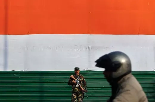 An Indian security personnel stands guard as a motorist passes by near India Gate, ahead of the Republic Day parade in New Delhi January 23, 2015.