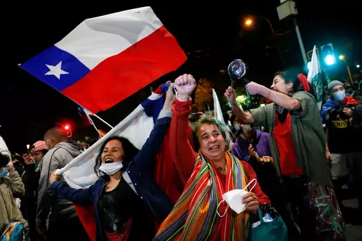 Women holding a Chilean flag celebrate