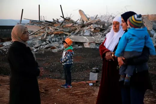 Arab citizens of Israel stand near demolished houses in the northern city of Qalansawe in January 2017.
