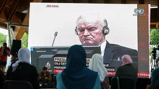 Bosnian families follow the final verdict hearing of the former Bosnian Serb general Ratko Mladic from a screen at the Srebrenica Genocide Memorial.
