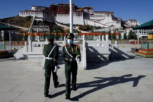 Paramilitary police officers swap positions during a change of guard in front of Potala Palace in Lhasa on October 15, 2020.