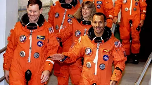Charles Bolden and other Space shuttle Discovery astronauts in orange space suits departing for the launching pad.