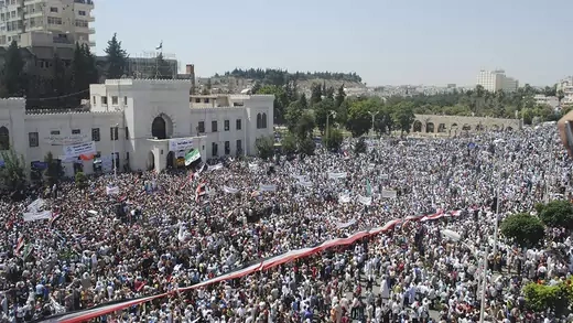 A giant Syrian flag is held by the crowd during a protest against President Bashar al-Assad.