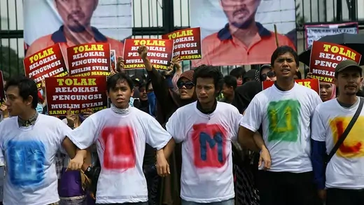 Indonesian Shiites Muslims rally outside the parliament building in Jakarta wearing t-shirts and holding placards.