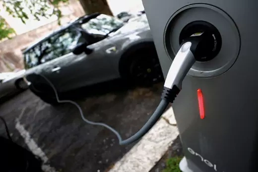 An electric car is seen plugged in at a charging point for electric vehicles in Rome, Italy, April 28, 2021.