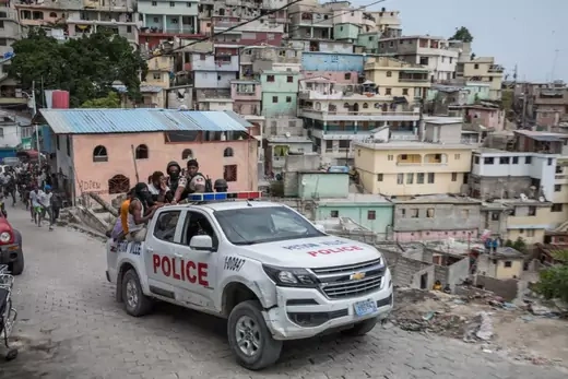A police car filled with civilians and policemen drives up the Jalousie township where men accused of being involved in the assassination of President Jovenel Moise, have been arrested on July 8, 2021.
