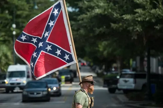 A Confederate flag supporter arrives at the South Carolina Statehouse on July 10, 2017 in Columbia, South Carolina. To mark the two year anniversary of the removal of the Confederate battle flag from statehouse grounds, demonstrators erected a pole and flew a replica for several hours at its former location.