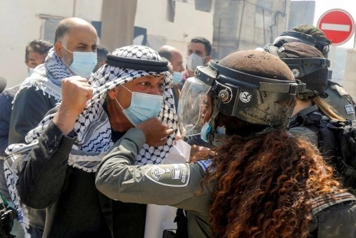 A Palestinian demonstrator scuffles with an Israeli border policewoman during a protest marking "Land Day", in Sebastia near Nablus, in the Israeli-occupied West Bank March 30, 2021.