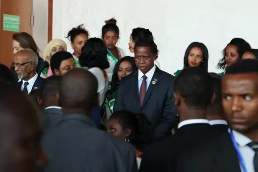 Zambia President Edgar Lungu stands looking towards a crowd at a meeting of the African Union.