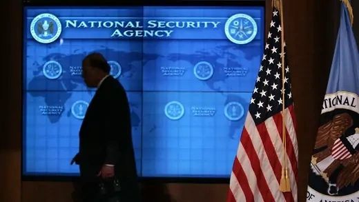 U.S. Director of National Intelligence John Negroponte walks past a video screen during a visit by President Bush to the NSA at Fort Meade, Maryland.