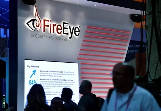 Attendees walk by the FireEye booth during the 2016 Black Hat cyber-security conference in Las Vegas