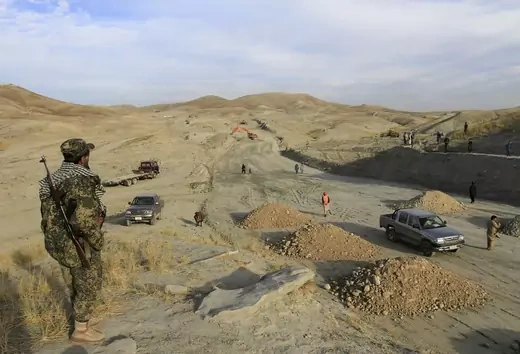 Afghan security personnel keep watch at a road construction site, which is being built by a Chinese company, in Khogyani district of Nangarhar Province on November 19, 2015.