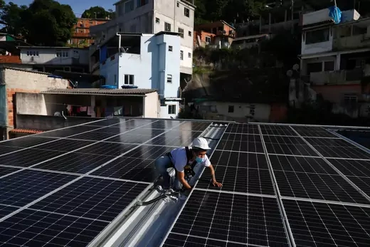 A worker installs solar panels in Rio de Janeiro