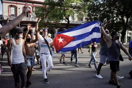 People hold Cuba's national flag during protests against and in support of the government, in Havana