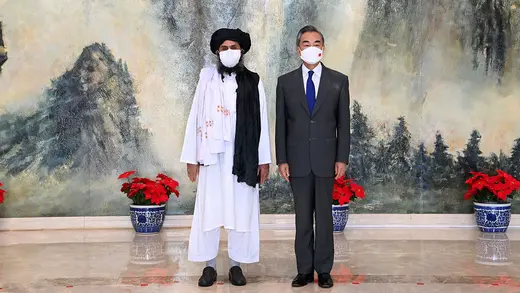 Mullah Abdul Ghani Baradar stands next to Foreign Minister Wang Yi.