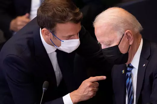 President Macron leans over and points at President Biden at the NATO Summit in Brussels