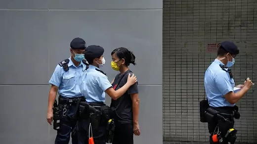A pro-democracy protester is being searched by police officers during a demonstration in Hong Kong. 