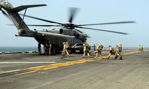 In this handout from the U.S. Navy, U.S. marines embarked aboard the amphibious assault ship USS Peleliu in the Indian Ocean board a Marine Corps helicopter August 12, 2010 in the Indian Ocean.