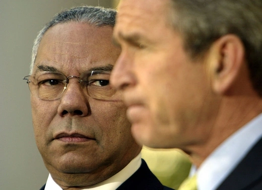 Secretary of State Colin Powell stands with President George W. Bush.