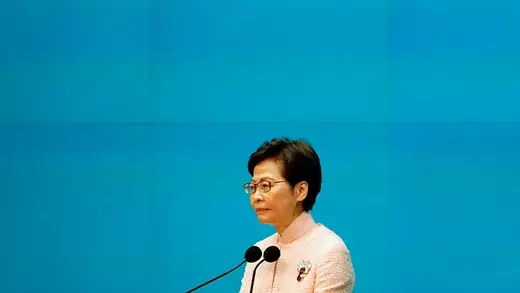 Hong Kong Chief Executive Carrie Lam speaks in front of a blue background