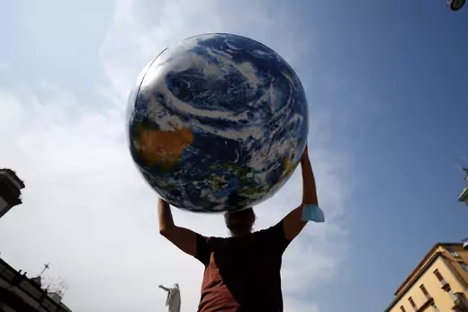 A person holds inflatable Earth as climate activists including Extinction Rebellion and Fridays for Future stage a protest demanding more action whilst G20 climate and environment ministers hold a meeting in Naples, Italy, July 22, 2021.