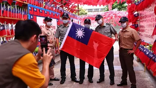 A group of soldiers takes photos at a square decorated with Taiwan flags
