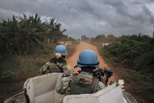Uruguayan peacekeepers in blue helmets and military gear look out atop a vehicle during a patrol in northeastern Democratic Republic of Congo.