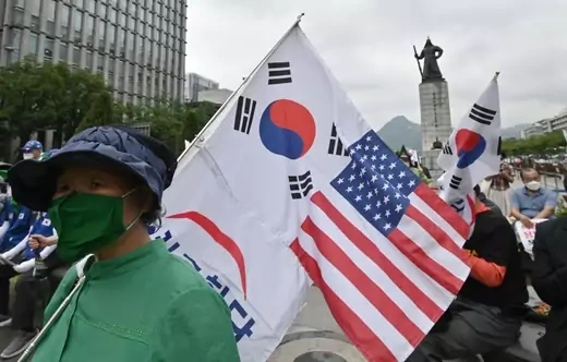 A South Korean woman holds flags of South Korea and the US during a rally commemorating the 70th anniversary of the beginning of the Korean War in Seoul on June 25, 2020.
