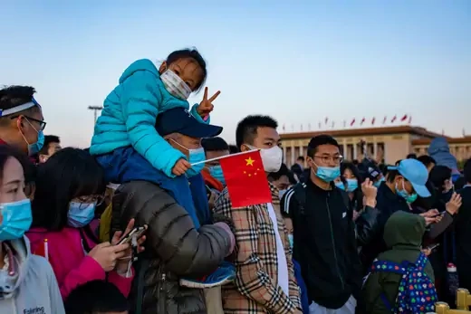 People watch a flag-raising ceremony at the Tian'anmen Square on the first day of the May Day holiday on May 1, 2021 in Beijing, China. May Day, also known as Labor Day, is observed on May 1 in China.