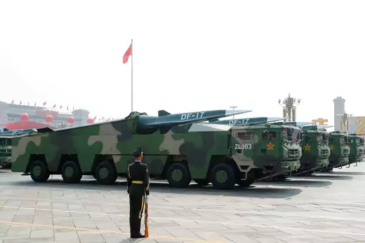 A Chinese soldier stands in front of military vehicles carrying hypersonic glide missiles DF-17.