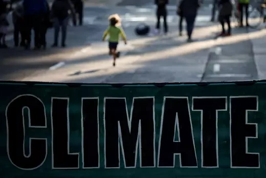 A child runs as climate change activists gather to protest outside of BlackRock headquarters ahead of the 2021 United Nations Climate Change Conference (COP26), in San Francisco, California, U.S., October 29, 2021.