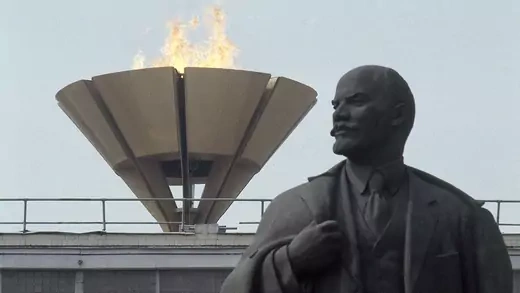 The Olympic flame burns above a statue of former Soviet leader Vladimir Lenin in Moscow.